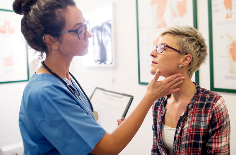 Young caucasian woman with female doctor checking pulse on her neck